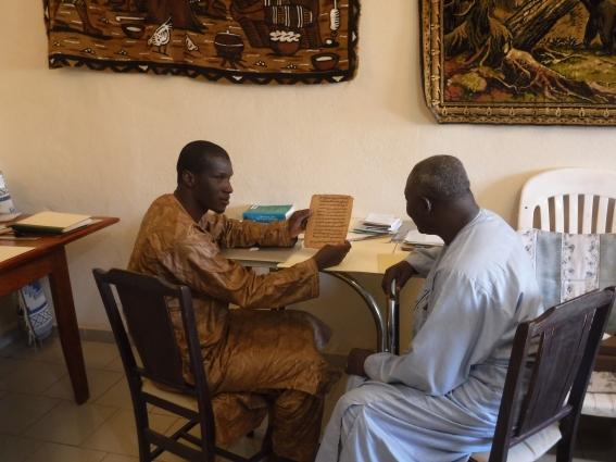 Pastor Yattara consulting with a colleague on the items to be digitised